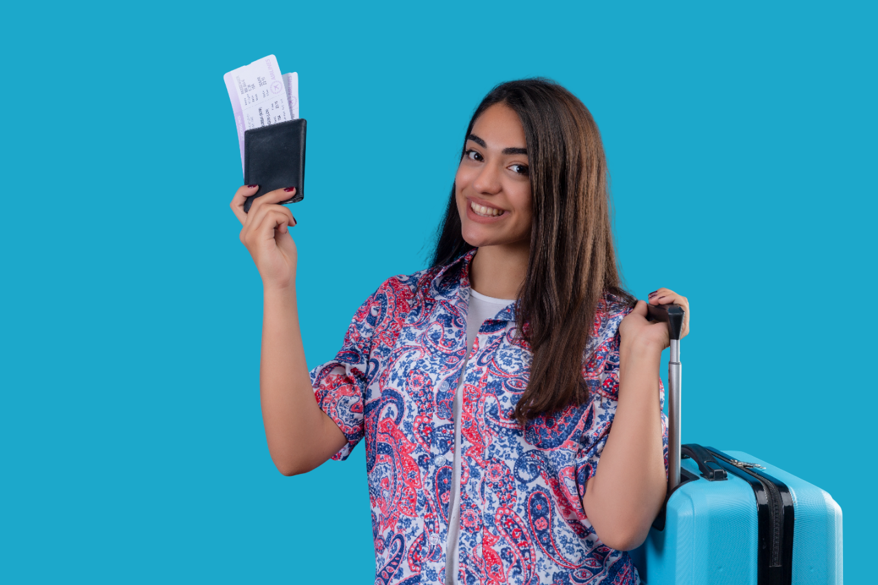 beautiful tourist woman holding travel suitcase passport with tickets with smile face happy positive travel concept standing blue space Photoroom